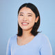 Woman wearing a light blue shirt against a solid blue background