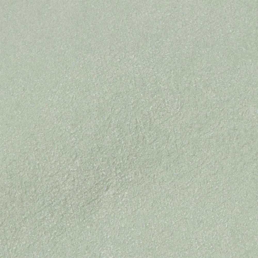 A close-up of a light grey, textured fabric surface, likely suede. The material appears soft and slightly fuzzy, conveying a sense of warmth and comfort.