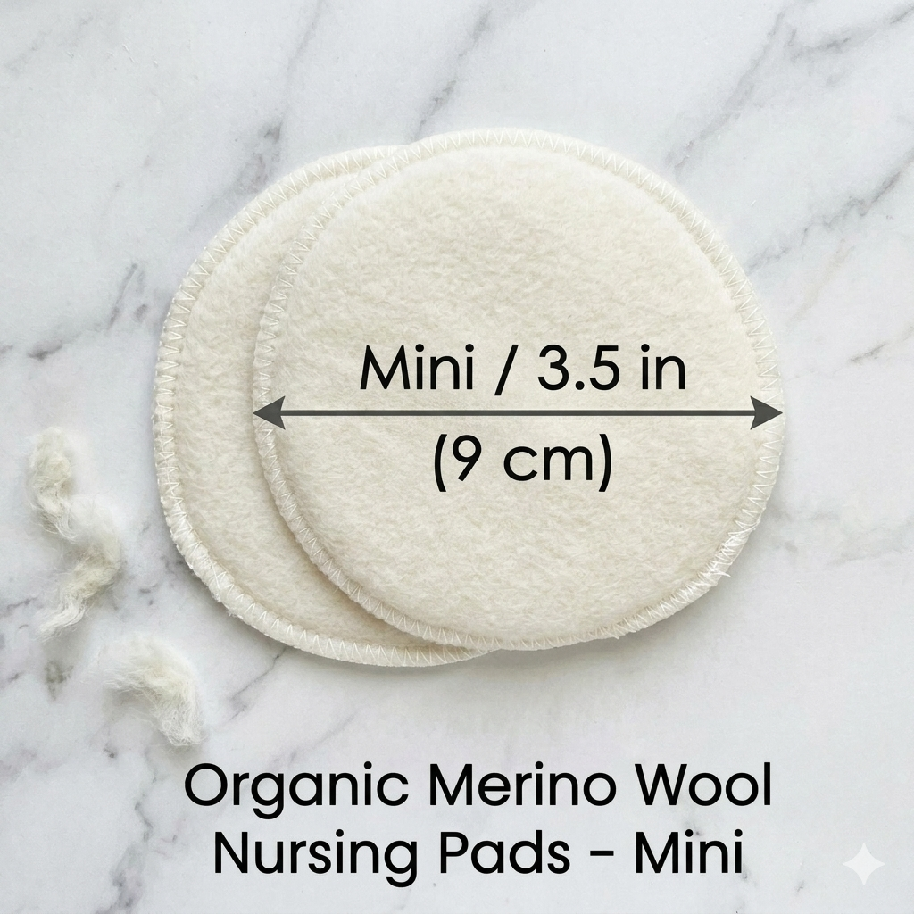 Two organic merino wool nursing pads on a marble surface with measurement text.