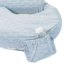 Light blue textured fabric covering a product with a water bottle underneath on a white background