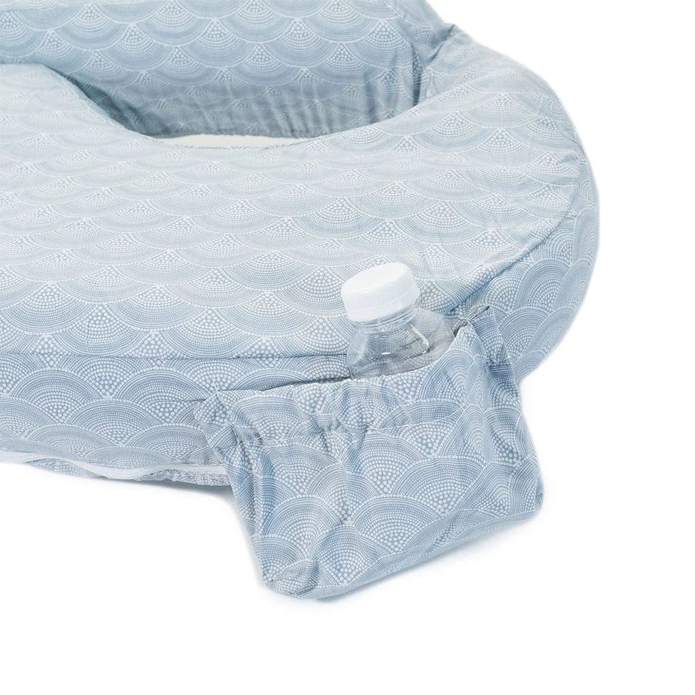 Light blue textured fabric covering a product with a water bottle underneath on a white background