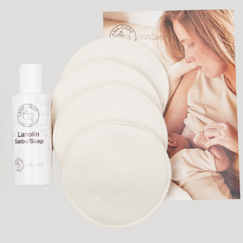 LANACare lanolin soap bottle with nursing pads, woman holding baby in the background
