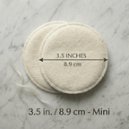 Two circular pads on a marble surface with measurement text