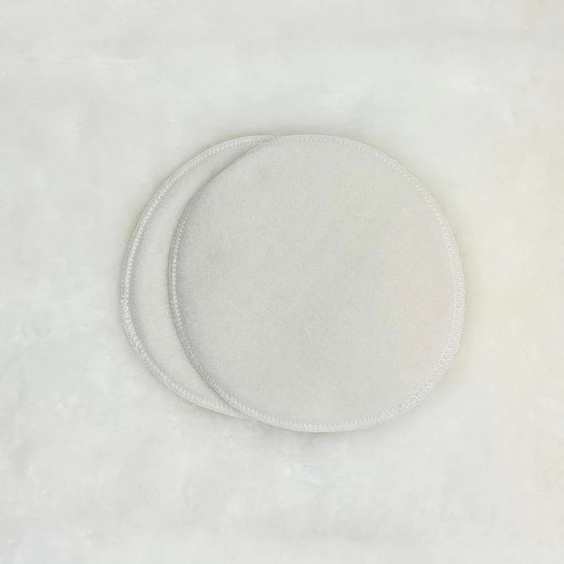 Two white ceramic plates with subtle patterns on a light gray background
