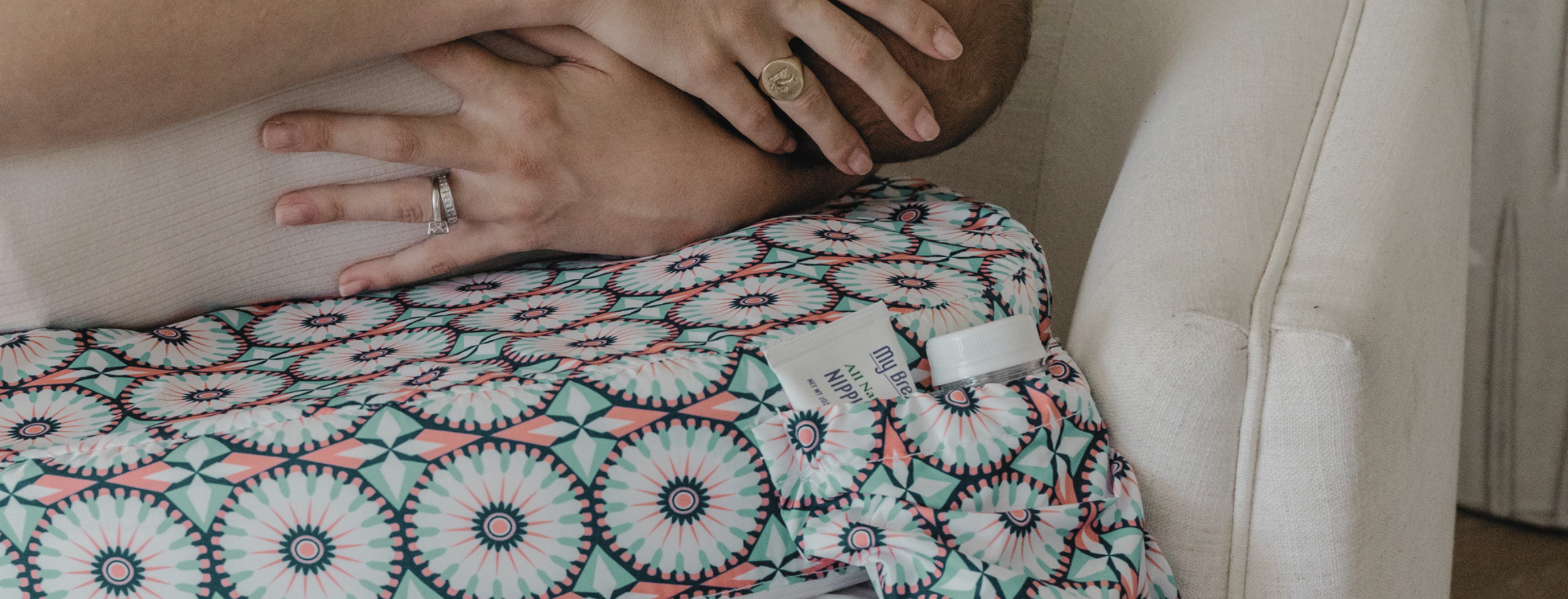 Person wearing a patterned skirt sitting on a couch with a visible brand label.