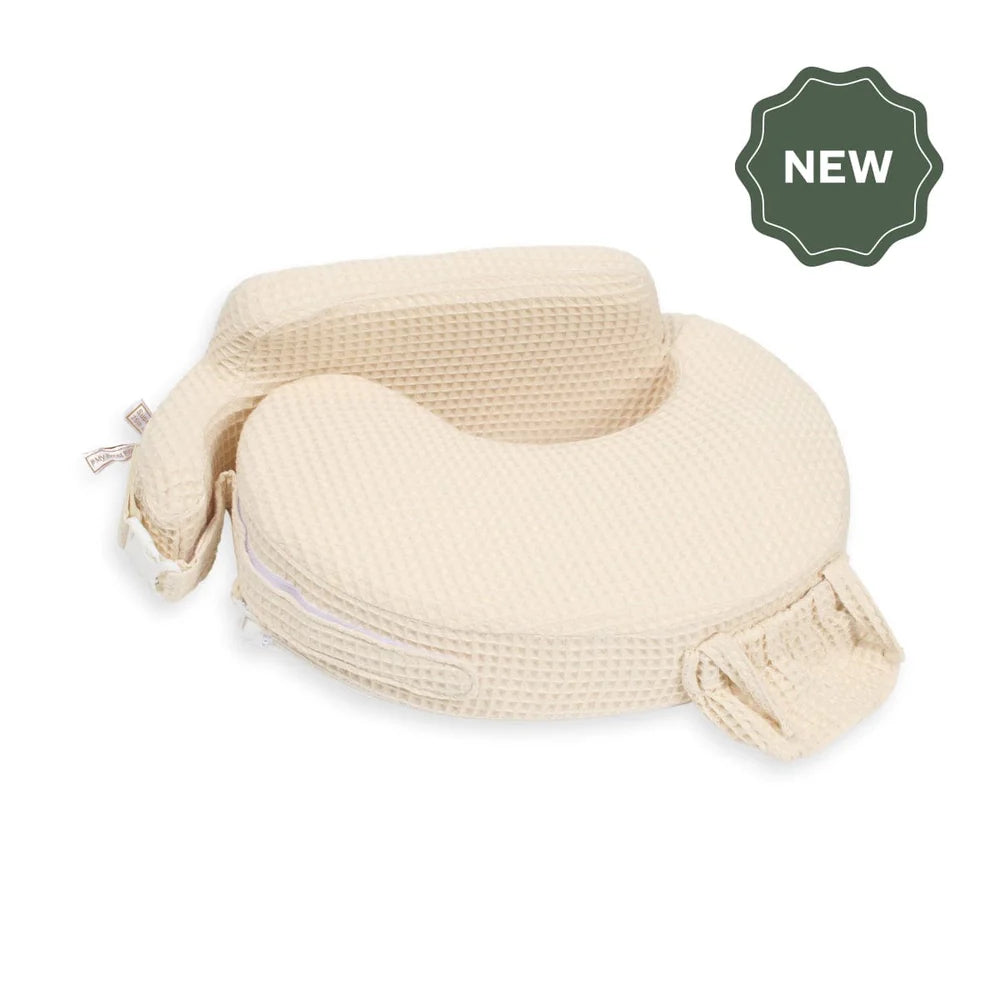 My Brest Friend nursing pillow in a cream waffle-weave fabric, featuring a wrap-around cushion design, integrated back support, side pocket, and a dark green "NEW" badge overlay